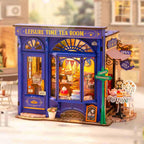 Miniature cafe kit with a warm lit window display of tiny cakes and treats, a handmade tea shop scene for hobbyists