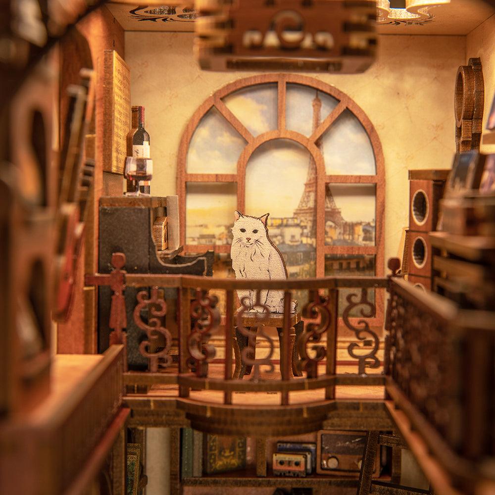 Lamplit book nook music room with an arched window view and balcony details for a miniature bookshelf display SZ003