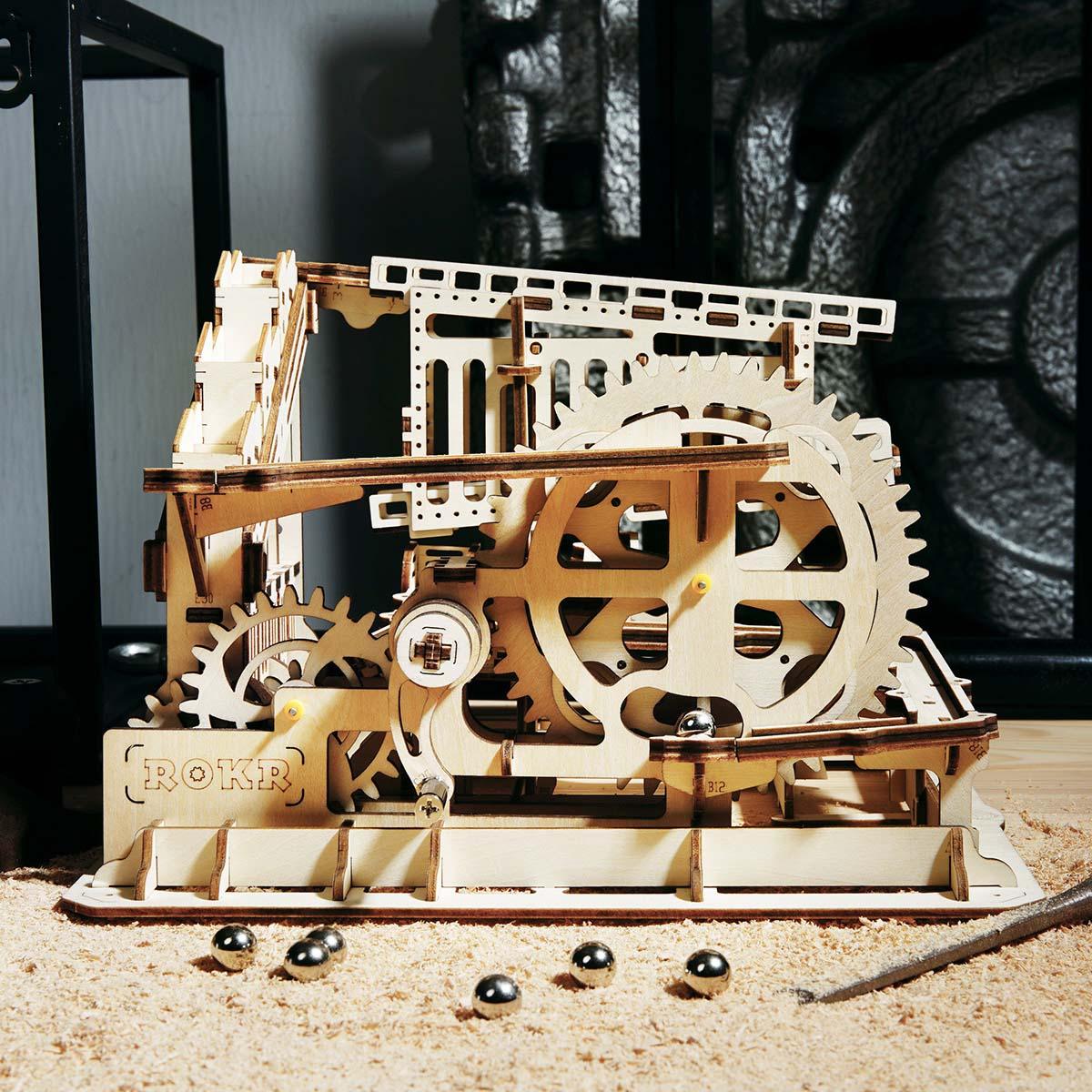 Marble run with turning gears and a wheel lifter raising marbles, a kinetic wooden model and STEM build for teens and adults