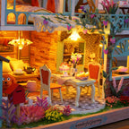 Outdoor dining terrace with cake, orange chairs and a glowing pendant lamp among climbing vines in a tropical miniature model