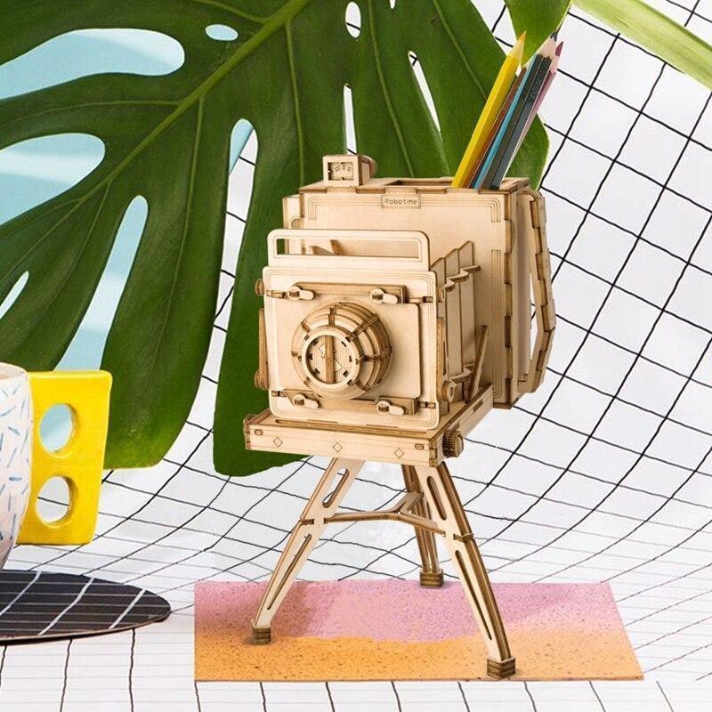 Playful wooden camera puzzle holding colored pencils as a bright desk accent, a screen free craft kit and gift for hobbyists