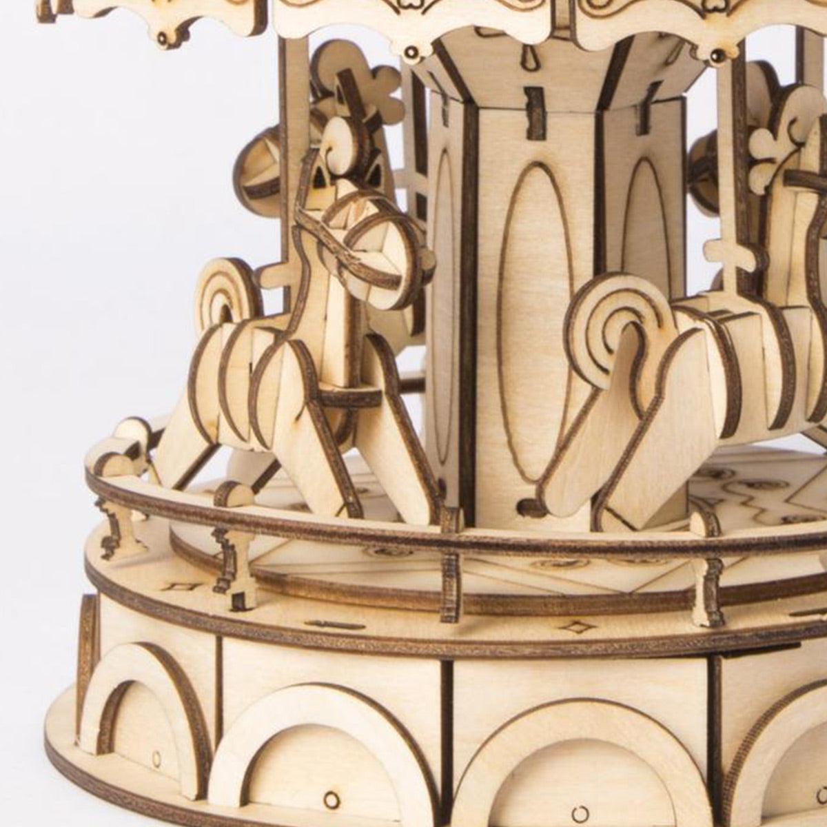 Laser-cut wooden carousel horses around a decorated center post, a hand-rotating fairground model kit for teen and adult hobbyists