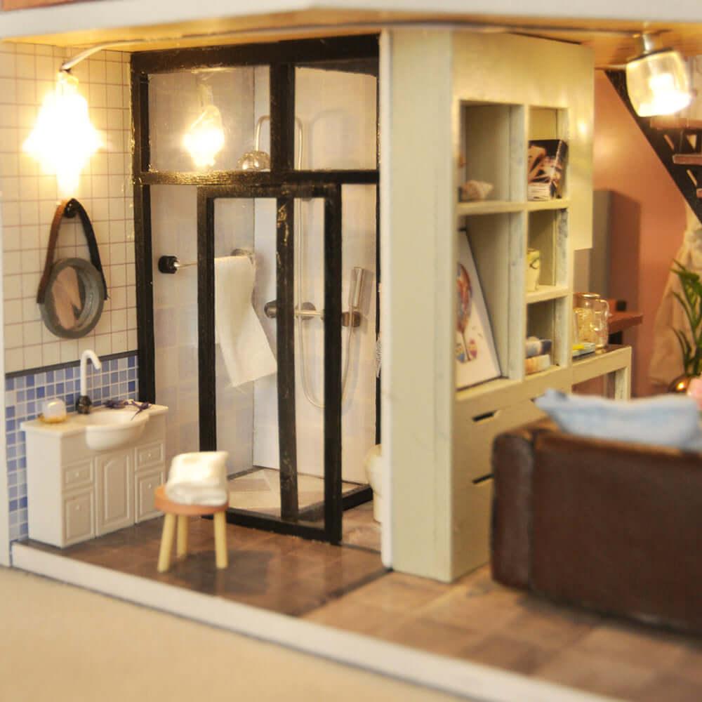 Tiny furnished bathroom with a glass shower and pedestal sink, a detailed miniature house craft kit for hobbyists