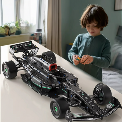 Child playing with a large scale model of a racing car in a room.