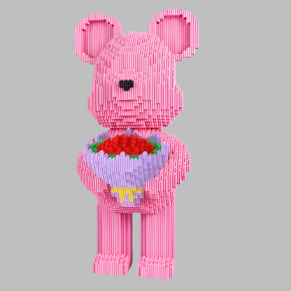 Pink bear-shaped toy holding a bouquet of flowers on a gray background