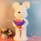 Teddy bear building block model with a bouquet, measurements indicated, on a gradient background.