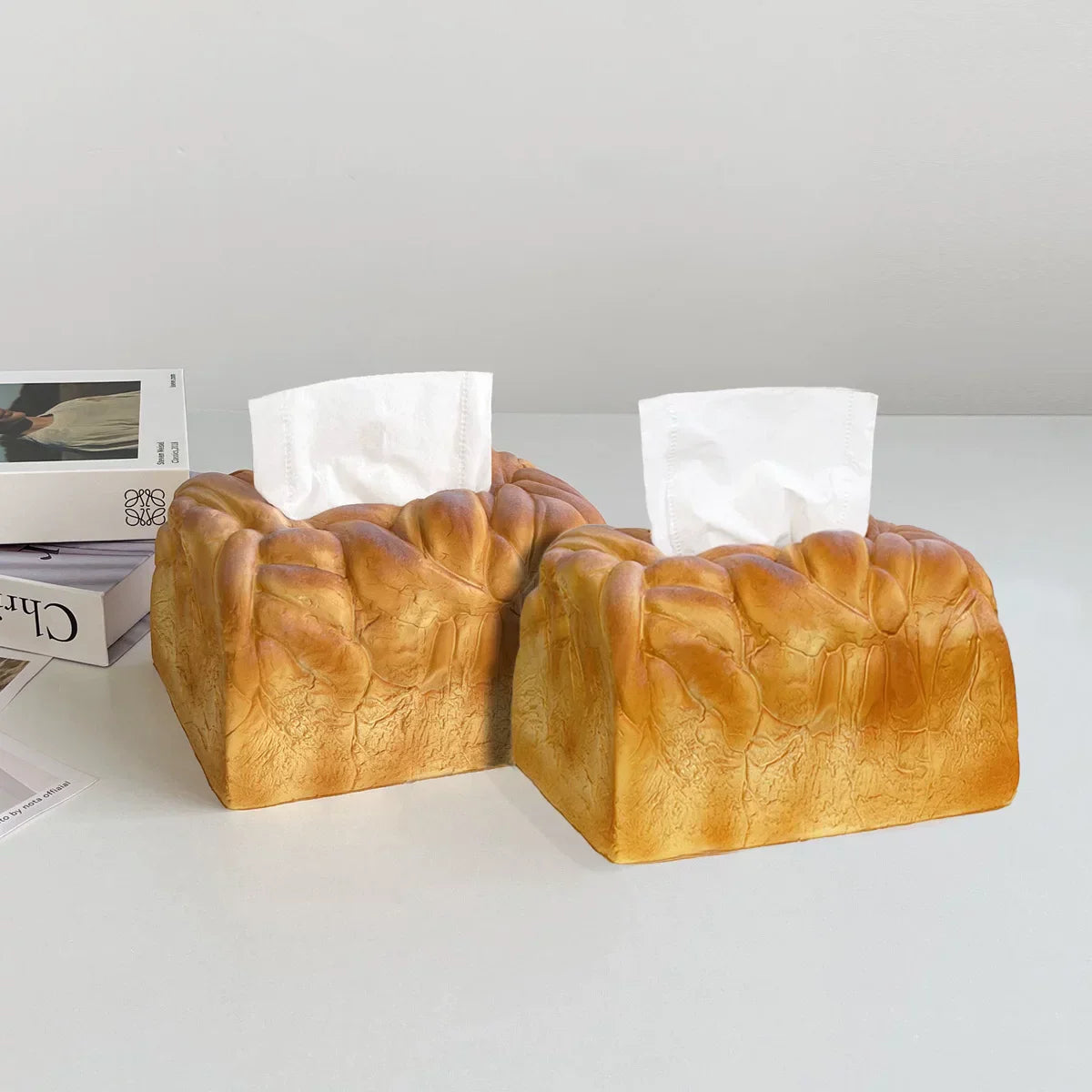 Two bread-shaped tissue boxes on a white surface with a light gray background.