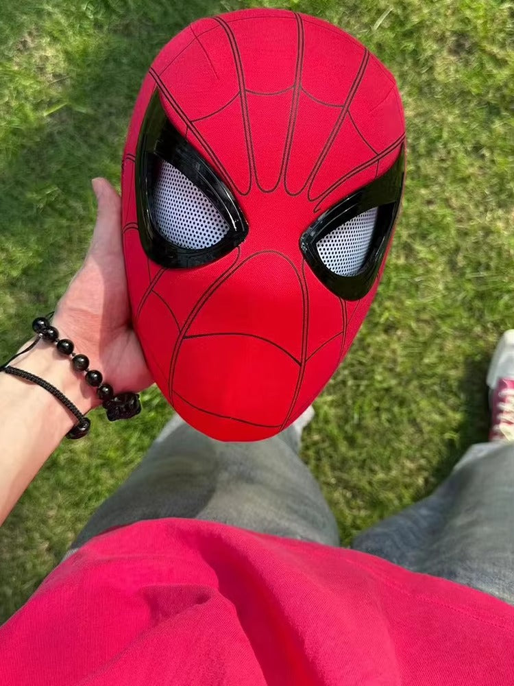 Person holding a red superhero Spider-Man superhero mask with electronic moving eyes and LED lights for cosplay and Halloween costumes